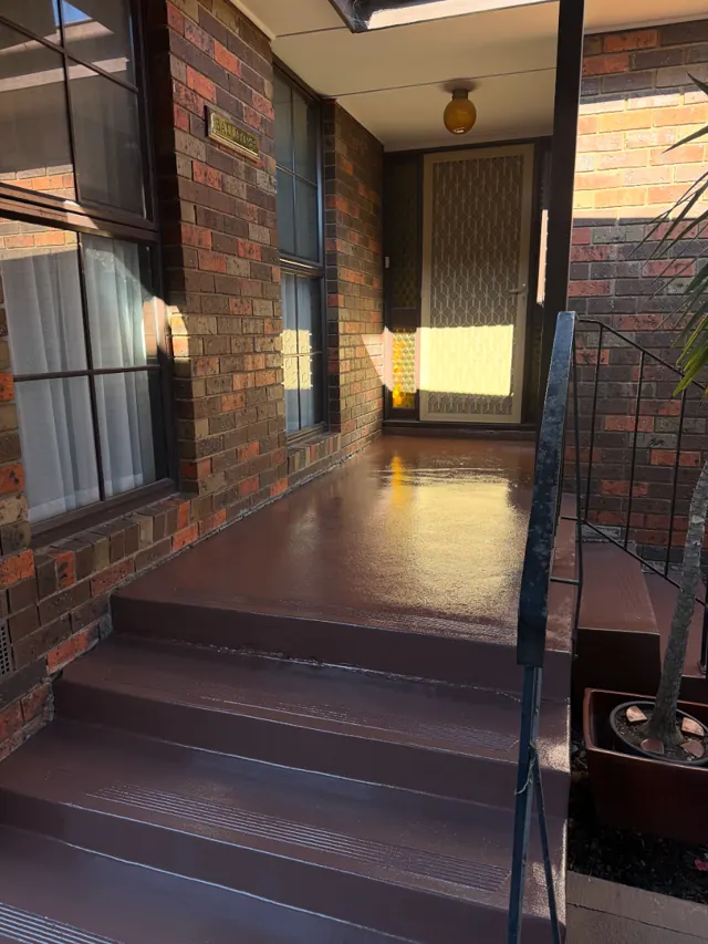 Brick porch with steps painted glossy red-brown