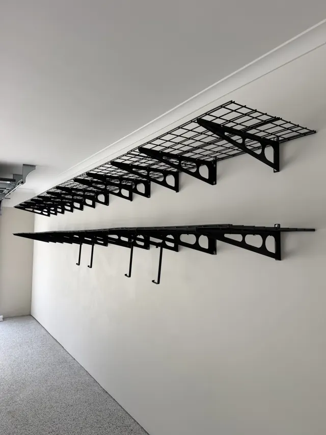 Black mesh shelving and hook rails on a garage wall