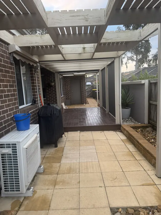 Long white pergola over a freshly cleaned paved walkway