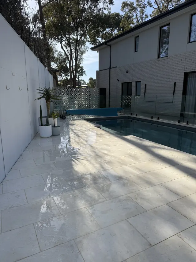 Pale pool surround tiles pressure cleaned and glossy