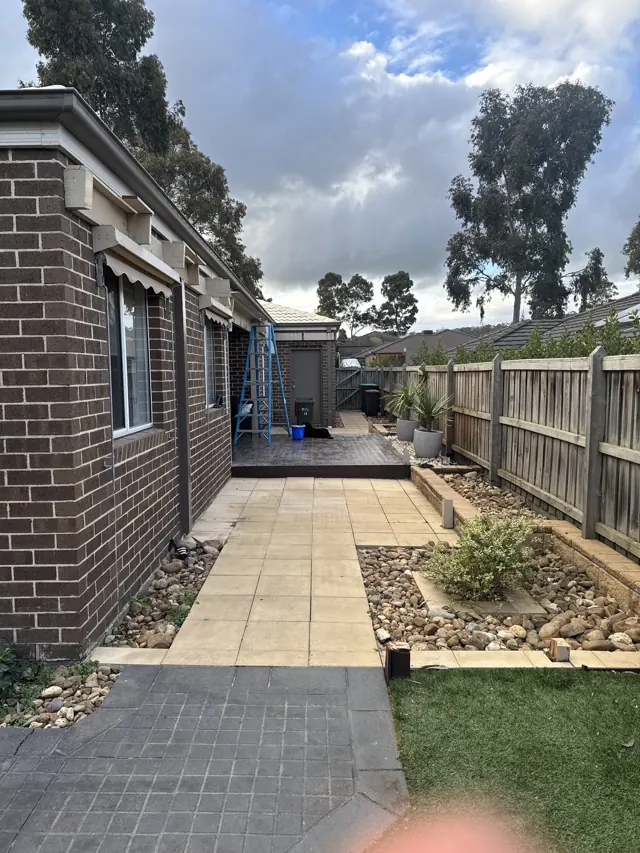 Side yard with paving, pebble garden beds and lawn